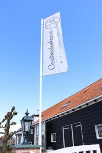 a street sign on a pole in front of a building at Oostmolenhoeve B&B in Goes
