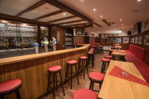 eine Bar mit roten Barhockern in einem Restaurant in der Unterkunft Hotel Willinger Mitte in Willingen