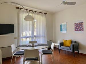a living room with a table and chairs and a tv at Jolly Apartments in Sirmione