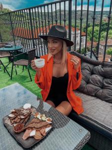 a woman sitting at a table with a plate of food at Tsarevets Design and Spa in Veliko Tŭrnovo