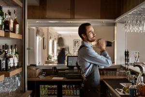 a man standing in front of a bar at Hotell Villa Långbers in Tällberg