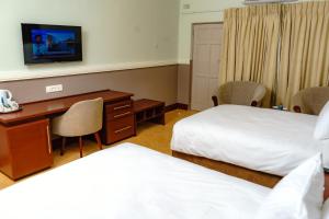 A bed or beds in a room at Great Zimbabwe Hotel