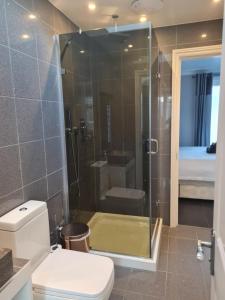 a bathroom with a glass shower with a toilet at Private luxury Annex apartment with secure free parking in Chessington +13 photos