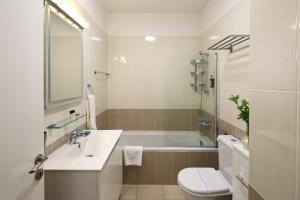 a bathroom with a tub and a sink and a toilet at Elysia Park in Paphos