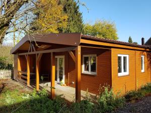 ein kleines Haus mit einer Veranda und einer Terrasse in der Unterkunft Les Dames de la Montagne in Frauenberg