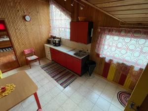 a small kitchen with red cabinets and a sink at Tuuli Majutus in Tõrva