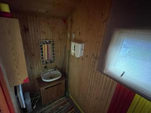 a small bathroom with a sink and a window at Tuuli Majutus in Tõrva