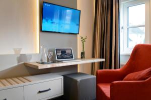 a room with a desk with a laptop and a chair at Landgasthof Kleiner in Sundern