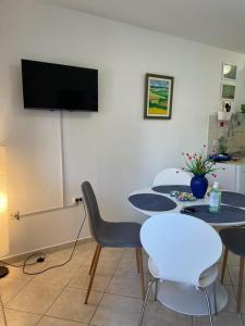 a room with three tables and a tv on a wall at Apartments Pape in Malinska