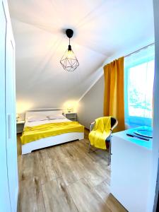 a bedroom with a yellow bed and a desk at Pokoje gościnne Lisa in Władysławowo