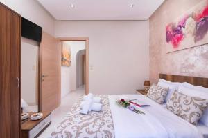a bedroom with a large white bed with flowers on it at Pension Maria in Astris