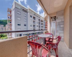 a balcony with a table and chairs and a building at Apartments Pedja Zec in Budva