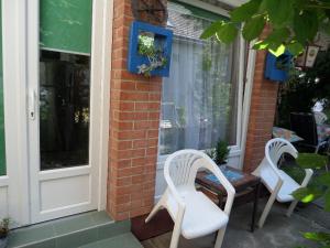 two white chairs and a table on a porch at Bori Apartmanok in Hajdúszoboszló
