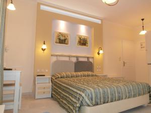 a bedroom with a bed and a desk and lights at Katerina Hotel in Agios Prokopios