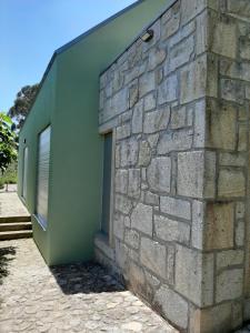 a stone wall with a door on the side of a building at Casa do Eido dos Calhões in Ponte de Lima