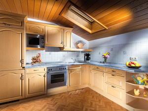a large kitchen with wooden cabinets and stainless steel appliances at Scheffaulehen Ferienwohnungen in Ramsau