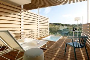 a balcony with a table and chairs on a wooden deck at Palladium Hotel Menorca in Arenal d'en Castell