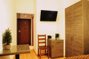 シフィノウイシチェにあるSky Roomsのデスク、壁掛けテレビが備わる客室です。