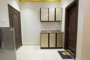 a bathroom with a sink and a mirror and a door at Al Rayah Aparthotel Weekly and Monthly Rental in Jeddah