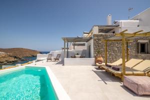 a patio with a swimming pool and a villa at Miramare Suites Mykonos in Merchia Beach