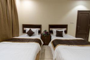 Al Rayah Aparthotel Weekly and Monthly Rental tesisinde bir odada yatak veya yataklar