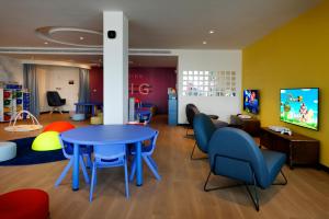 a childrens playroom with a blue table and chairs at Palladium Hotel Menorca in Arenal d'en Castell