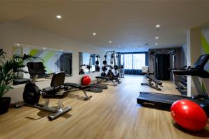 a gym with a bunch of exercise equipment in a room at Palladium Hotel Menorca in Arenal d'en Castell