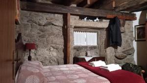 ein Schlafzimmer mit einem Bett in einer Steinmauer in der Unterkunft Stone House in Vila Real
