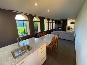 a kitchen and living room with a table and chairs at Apartaments Parapent Fly Escales in Organyà