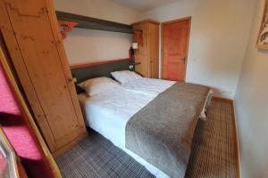 1 dormitorio con 1 cama grande y puerta de madera en Arc 1950 Résidence 5* Sources de Marie 4/6 pers, en Arc 1950 10 fotos más