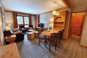 sala de estar con mesa y sillas y sala de estar. en Arc 1950 Résidence 5* Sources de Marie 4/6 pers, en Arc 1950