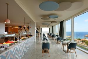 a restaurant with a view of the ocean at Palladium Hotel Menorca in Arenal d'en Castell