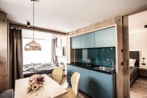 Il comprend une cuisine et un salon avec une table et un canapé. dans l'établissement Mysciliar Apartment Tree ii, à Alpe di Siusi