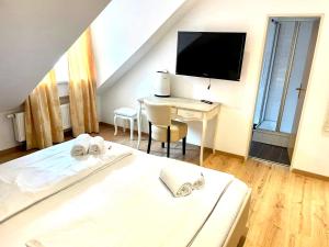 a bedroom with a bed and a desk with a television at Anker Self-Check-In Hotel in Lindau +46 photos