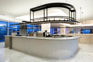 a kitchen with a large chandelier above a counter at Palladium Hotel Menorca in Arenal d'en Castell