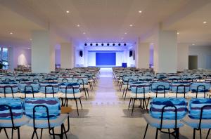a room with rows of chairs and a stage at Palladium Hotel Menorca in Arenal d'en Castell
