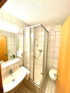 a bathroom with a shower and a sink at Anker Self-Check-In Hotel in Lindau