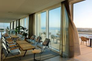 a room with tables and chairs on a balcony at Palladium Hotel Menorca in Arenal d'en Castell