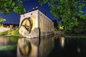 a building on a bridge over a river at night at Hotel Gabriella in Tapolca
