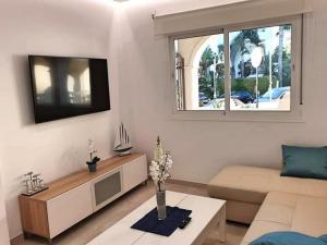 a living room with a couch and a tv at Apartamento Puerto Marina Beach in La Carihuela