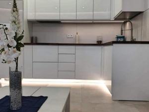 a kitchen with white cabinets and a vase of flowers at Apartamento Puerto Marina Beach in La Carihuela