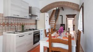 une cuisine avec une table et une salle à manger dans l'établissement Welcomely - La Casa di Annetta, à Gonnesa