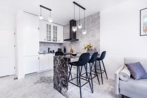 a kitchen and living room with a table and chairs at Apartament Róża Wiatrów Giżycko/Wilkasy in Wilkasy