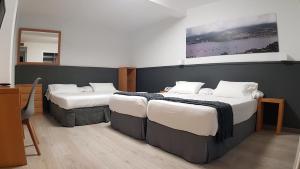 Habitación con 2 camas en una habitación con espejo. en Hotel del Mar Vigo en Vigo
