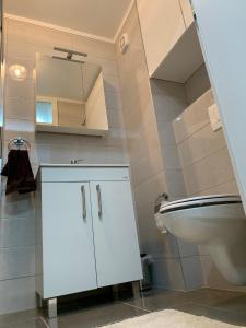 a white bathroom with a sink and a toilet at Apartman Jasmin - Blizu Panonskih jezera i centra grada in Tuzla