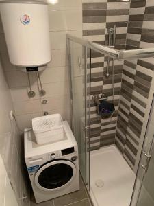 a small bathroom with a washing machine in it at Apartman Jasmin - Blizu Panonskih jezera i centra grada in Tuzla