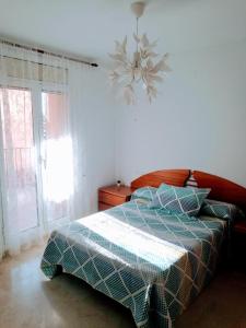 Schlafzimmer mit einem Bett und einem Kronleuchter in der Unterkunft Tirwal Suite Judería in Teruel