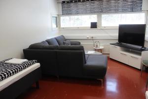 a living room with a couch and a flat screen tv at Metsäkartano in Kannus