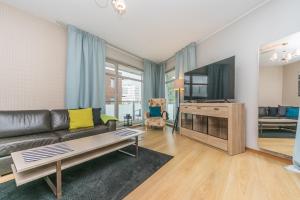 a living room with a couch and a flat screen tv at Glow Apartments, Apartament Marina in Gdańsk