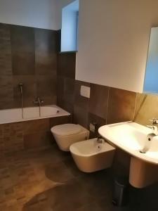 a bathroom with two sinks and a toilet and a tub at Albergo della Posta in Mondovì